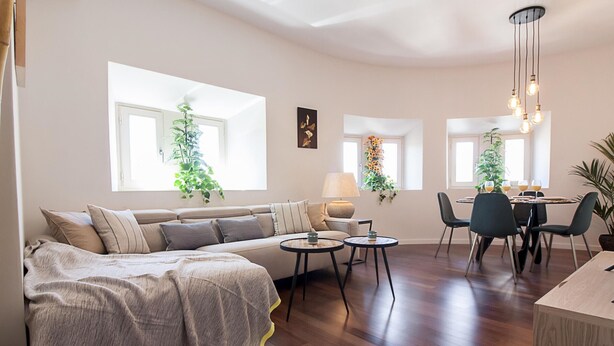 Un salon moderne comprenant un canapé, une table à manger avec des chaises et un coin cuisine.