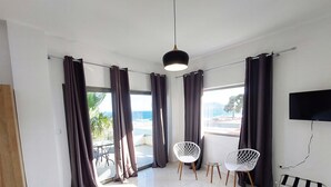 A modern room with large windows, a ceiling light, and two white chairs. - Finikas Suites & Apartments Airport (Spata-Artemida)