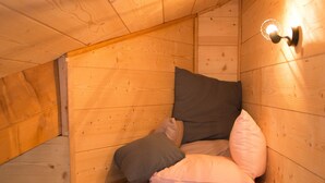 Ein gemütliches Schlafzimmer im Dachgeschoss mit Holzwänden und schrägen Decken.