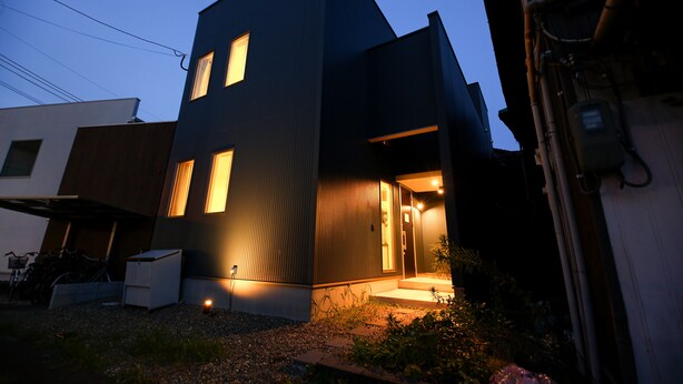 A modern two-story building with a dark facade and illuminated windows. - PrimeRoomBeppu Hamawakionsenmae (Beppu)