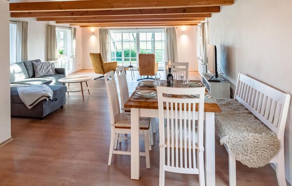 Relax in this open-plan living and dining area, featuring a sofa, chair, and dining table.