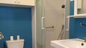 A bathroom with a toilet, a sink, and a shower.