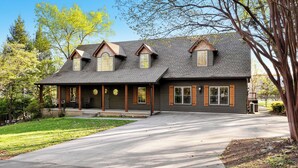 A two-story house with a covered porch, a garage, and a driveway.