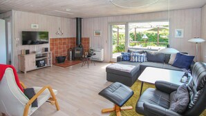 A modern living room with a sofa, ottoman, and a television. - 2 bedroom beautiful home in Samsø (Samsø)