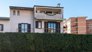 Ein modernes, zweistöckiges Gebäude mit Flachdach, großen Fenstern und einem Balkon.
