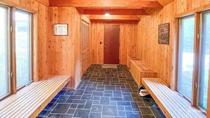 Un sauna de madera con bancos y una puerta.