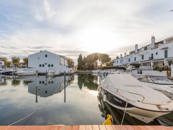 A marina with boats docked, a white building, and a clear sky.