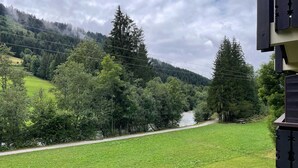 A river with a path alongside it, surrounded by dense forest and hills. - 2-room apartment near slopes with balcony (La Chapelle-d'Abondance)