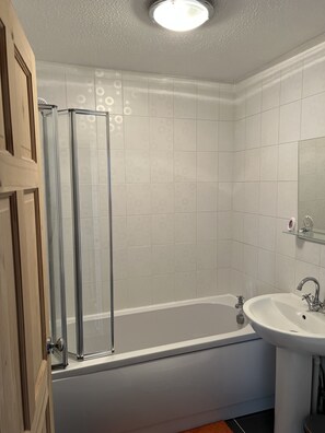 Ein Badezimmer mit Badewanne, Waschbecken und Duschkabine.