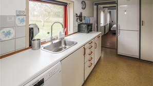 Una cocina con lavavajillas, un lavabo y una ventana con vistas a un jardín.