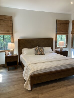 Cozy retreat with a large bed, two nightstands, and a window with a wooden blind.