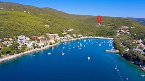 An aerial view of a coastal town with a marina, houses, and a forested hill. - Gorgeous home in Labin (Labin)