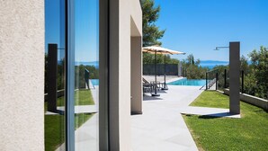 A modern outdoor patio with a pool, seating, and a clear view of the landscape. - Gorgeous home in Labin (Labin)