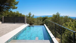 A swimming pool with a view of the sea and mountains, surrounded by trees and a fence. - Gorgeous home in Labin (Labin)