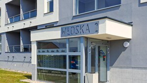A modern building with a sign reading "WŁOSKA 2" indicating a property or business. - 1 bedroom cozy apartment in Koszalin (Koszalin)