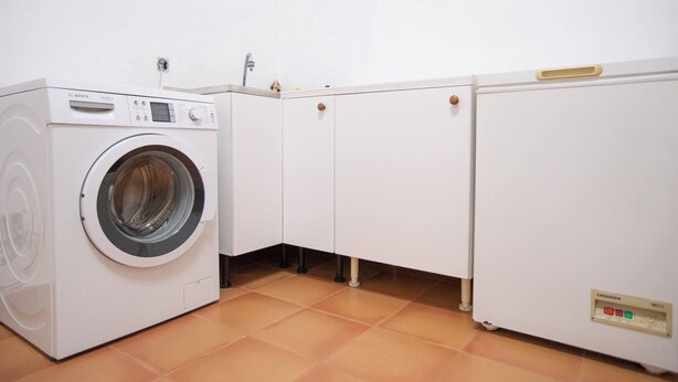 A laundry room with a Bosch washing machine, a dryer, and cabinets. - Nice 3 Bedroom Villa in El Duque  (Costa Adeje)