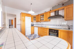 Une cuisine moderne avec des meubles en bois, un four encastré et un pare-feu en carreaux.