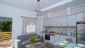 A modern kitchen with white cabinets, a built-in oven, and a stainless steel refrigerator. - Villa Vasso Two-Bedroom Sea View Residence near Kerasia Beach (Αγνίτσινη)