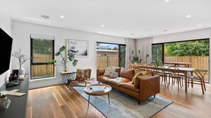 Relax in this stylish living space with a sofa, armchair, and dining area, perfect for meals and gatherings.