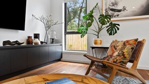 Relax in this serene space with a comfortable chair by the window, a reading nook, and a TV for entertainment.