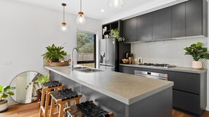 Enjoy cooking in this well-equipped kitchen with a central island, stainless steel appliances, and ample counter space.