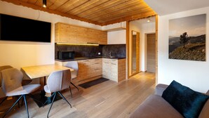 Una cocina moderna con armarios de madera, una mesa de comedor con sillas y un cuadro grande en la pared.