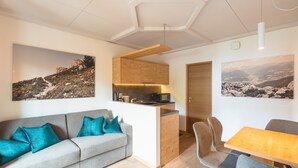 Een moderne woonruimte met een bank, een eettafel en een keukenhoek.
