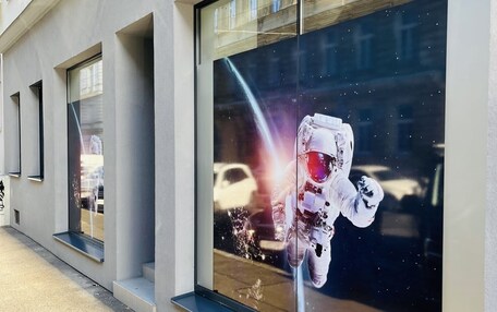 A building with large windows and a poster of an astronaut.