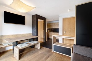 Une cuisine moderne avec des meubles en bois, un four encastré et une grande fenêtre.