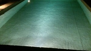 A swimming pool with a tiled floor and a light source at the corner. - Benozzo vacation apartment with garden and pool (Montefalco)