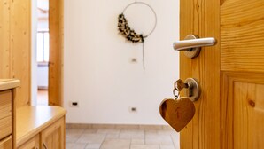 Una puerta de madera con un llavero en forma de corazón, un picaporte metálico y una cerradura.