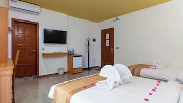 Une chambre d’hôtel équipée d’un lit, d’un bureau, d’une télévision et d’un porte-manteau.