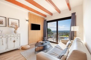 Ein modernes Wohnzimmer mit einer Couch, einem Couchtisch und einem an einer Holzwand befestigten Fernseher.