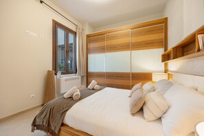 Un dormitorio con una cama, una ventana, un radiador y un armario de madera.