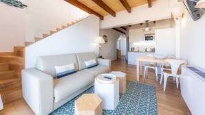 A modern living room with a sofa, coffee table, and a dining area with chairs and a table. - Vacation Home 'Sa Figuereta Living Place' with Mountain Views, Wi-Fi & Air Conditioning (ARIANY)