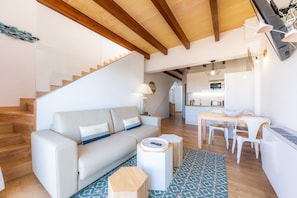 Un salon moderne comprenant un canapé, une table basse et un coin repas avec des chaises et une table.