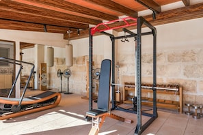 A gym with a pull-up bar, weight bench, and various exercise equipment. - Vacation Home 'Sa Figuereta Living Place' with Mountain Views, Wi-Fi & Air Conditioning (ARIANY)