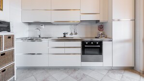 A modern kitchen with white cabinetry, stainless steel appliances, and a tiled backsplash.