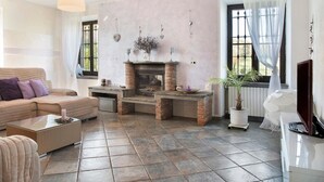 A living room with a fireplace, a sofa, a coffee table, and a television.