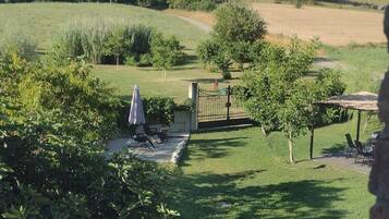 Una zona residenziale con piscina, cancello e una collina sullo sfondo con edifici.