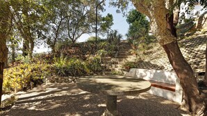 A stone bench surrounded by trees and plants, with a stone staircase in the background. - Holiday Home 'Quinta La Rabide' with Mountain View, Wi-Fi and Air Conditioning (Azeitão)