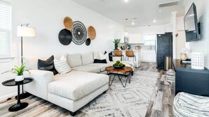 Un salon moderne avec un canapé, une table basse et des œuvres d’art décoratives au mur.