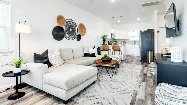 Un salon moderne avec un canapé, une table basse et des œuvres d’art décoratives au mur.