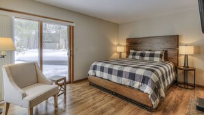 Een slaapkamer met een groot bed, een stoel, een tafel en een televisie.