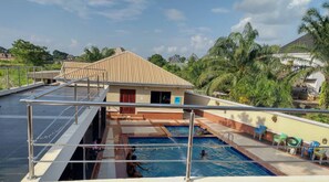 Une piscine sur le toit offrant une vue sur un quartier résidentiel et des palmiers.