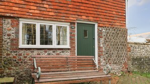 A brick house with a green door and white-framed windows. - 48 Polecat Cottages (Lewes)