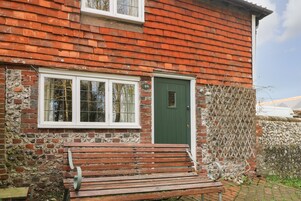 A brick house with a green door and white-framed windows.