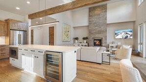 A spacious kitchen with a large island, wooden cabinets, and a built-in oven. - Hummingbird House | Luxury | River | Spa (Deschutes County)
