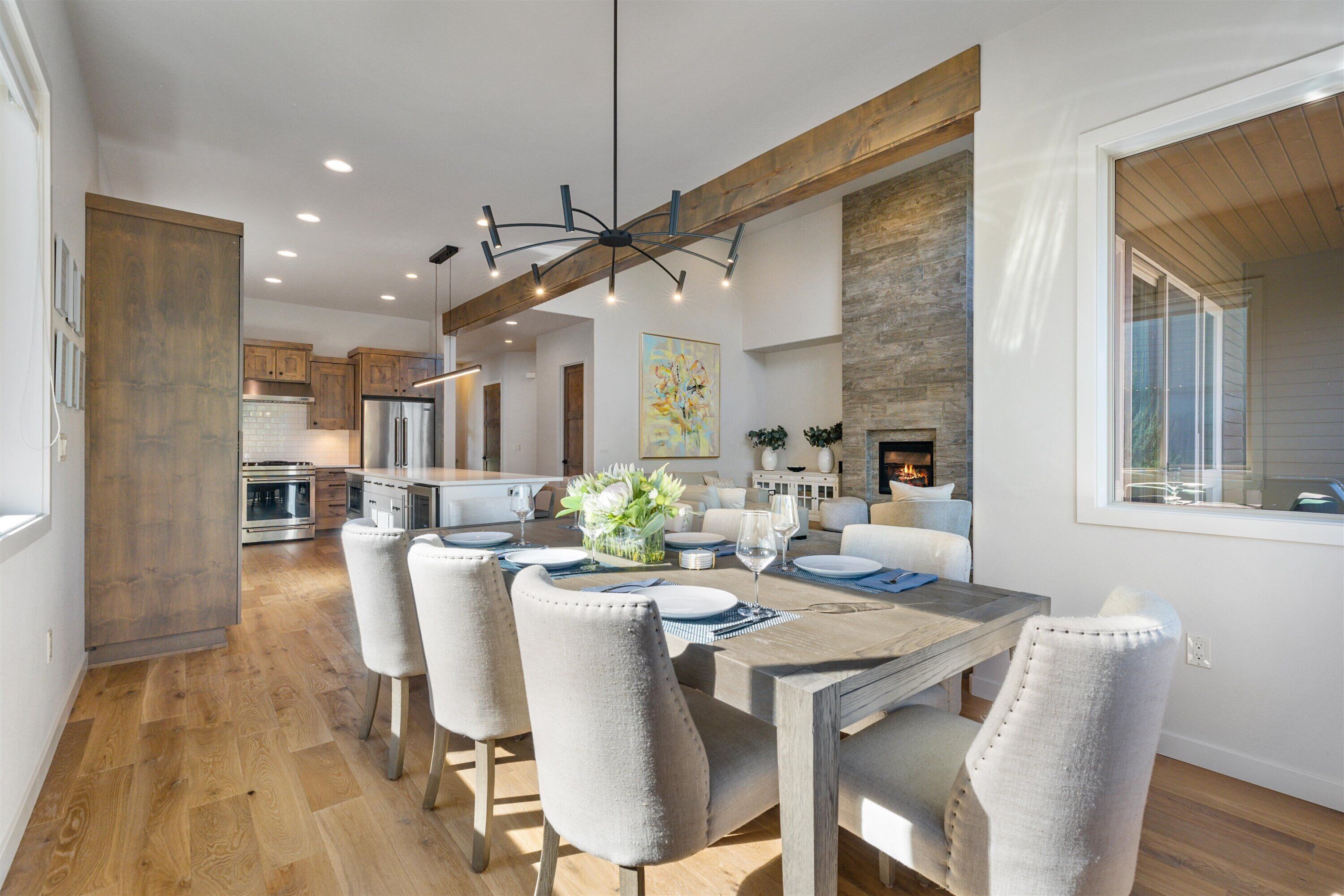 Una cocina moderna con electrodomésticos de acero inoxidable, un comedor con mesa y sillas de madera, y una chimenea.