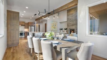 Una cocina moderna con electrodomésticos de acero inoxidable, un comedor con mesa y sillas de madera, y una chimenea.